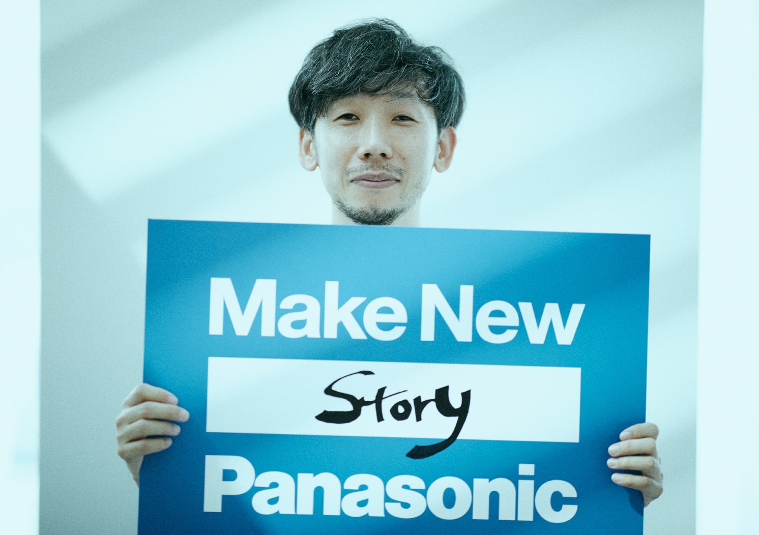 Make New Standardsのパネルを持つ 映像ディレクター 柳沢 翔(やなぎさわ しょう)氏 | Make New Magazine「未来の定番」をつくるために、パナソニックのリアルな姿を伝えるメディア